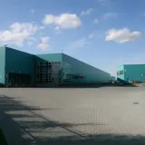 Nowoczesne magazyny w kolorze turkusowym, idealne do outsourcingu logistyki.