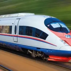 Szybki pociąg z czerwono-niebieskimi pasami mknie po torach. To idealny środek transportu dla każdej przesyłki konduktorskiej.