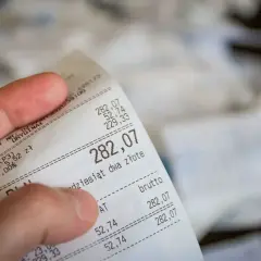 Dłoń trzyma paragon z kwotą 282,07 zł. Czy można zwrócić towar bez paragonu? To pytanie nurtuje wielu konsumentów.