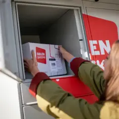 Kobieta wkłada paczkę gabarytową do paczkomatu ORLEN Poczta.