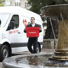 Kurier Citytrans z czerwoną skrzynką, gotowy do dostarczenia paczki tego samego dnia.