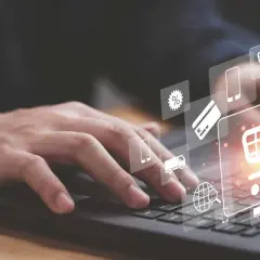 Dłoń na klawiaturze laptopa, ikony zakupów online, koszyk, karta kredytowa, procenty, wyszukiwanie globalne, telefon, ciężarówka – wszystko to pojawia się w samą porę.