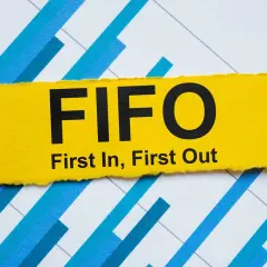 Żółty pasek z napisem FIFO (First In, First Out) na tle wykresu. Zasada FIFO w praktyce.