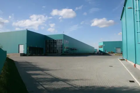 Nowoczesne magazyny w kolorze turkusowym, idealne do outsourcingu logistyki.