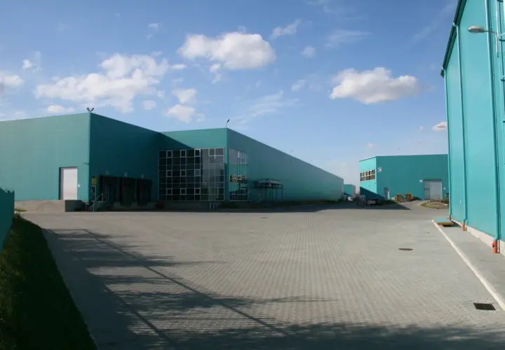 Nowoczesne magazyny w kolorze turkusowym, idealne do outsourcingu logistyki.