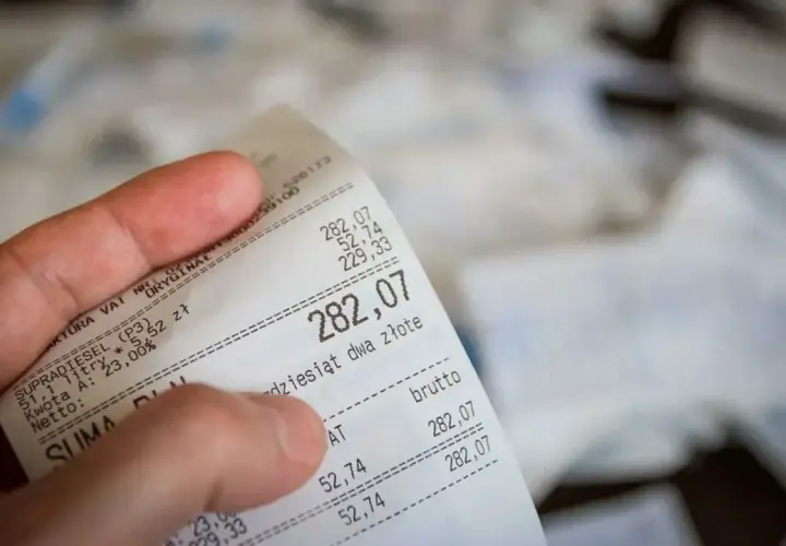 Dłoń trzyma paragon z kwotą 282,07 zł. Czy można zwrócić towar bez paragonu? To pytanie nurtuje wielu konsumentów.