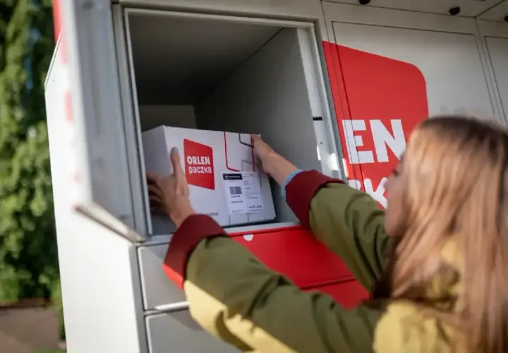 Kobieta wkłada paczkę gabarytową do paczkomatu ORLEN Poczta.