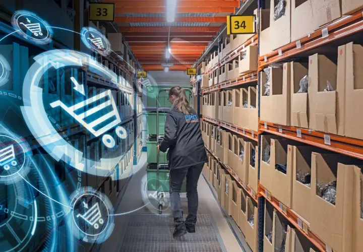 Kobieta w magazynie, gdzie nowe technologie w logistyce wizualizują procesy. Wózki i koszyki zakupowe symbolizują cyfrowy przepływ towarów.