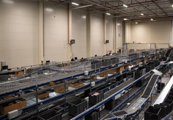 Nowoczesne centrum logistyczne z taśmociągami i pojemnikami, obsługujące usługi e-commerce.
