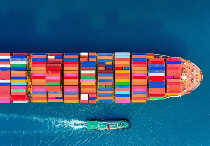 Kontenerowiec z kolorowymi kontenerami na morzu. CIF Incoterms co oznacza? Ubezpieczenie i fracht do portu docelowego.