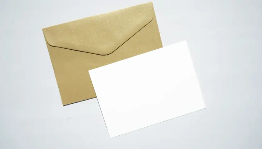 Złota koperta i biała kartka. Idealne, by dowiedzieć się, jak wysłać list.
