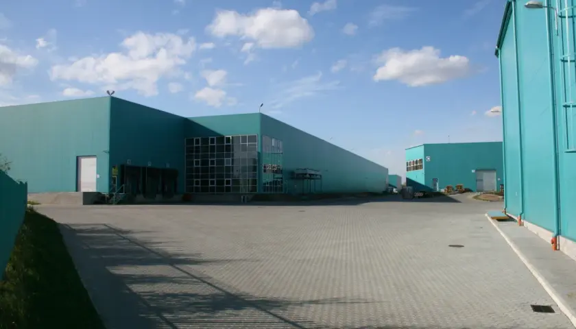 Nowoczesne magazyny w kolorze turkusowym, idealne do outsourcingu logistyki.