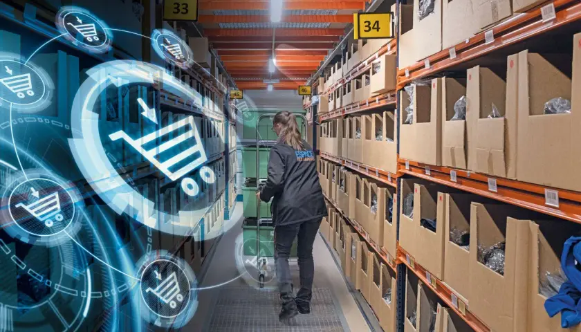 Kobieta w magazynie, gdzie nowe technologie w logistyce wizualizują procesy. Wózki i koszyki zakupowe symbolizują cyfrowy przepływ towarów.
