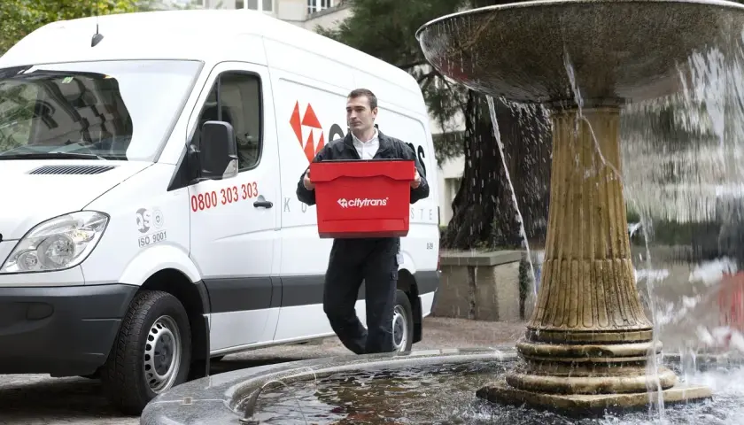 Kurier Citytrans z czerwoną skrzynką, gotowy do dostarczenia paczki tego samego dnia.