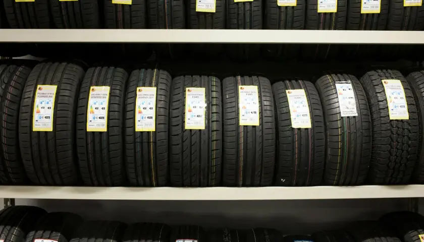 Rzędy opon samochodowych na półkach magazynu, gotowe do wysyłki DHL.