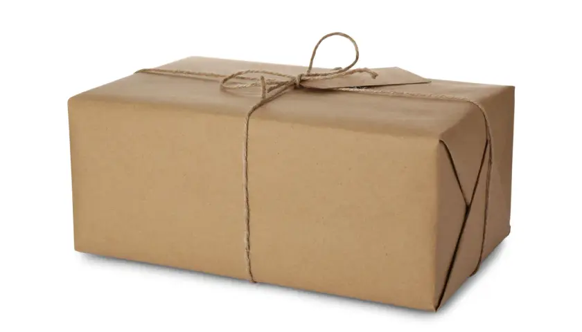 Paczka owinięta brązowym papierem, przewiązana sznurkiem. Idealna do wysyłki, gdy znasz DHL wymiary paczki.