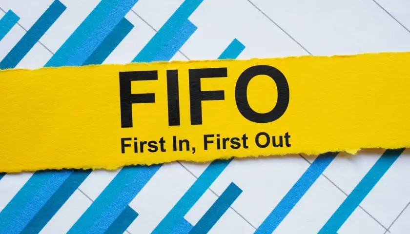 Żółty pasek z napisem FIFO (First In, First Out) na tle wykresu. Zasada FIFO w praktyce.