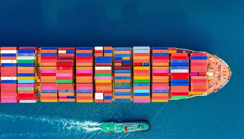 Kontenerowiec z kolorowymi kontenerami na morzu. CIF Incoterms co oznacza? Ubezpieczenie i fracht do portu docelowego.
