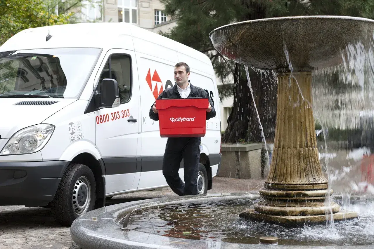 Kurier Citytrans z czerwoną skrzynką, gotowy do dostarczenia paczki tego samego dnia.