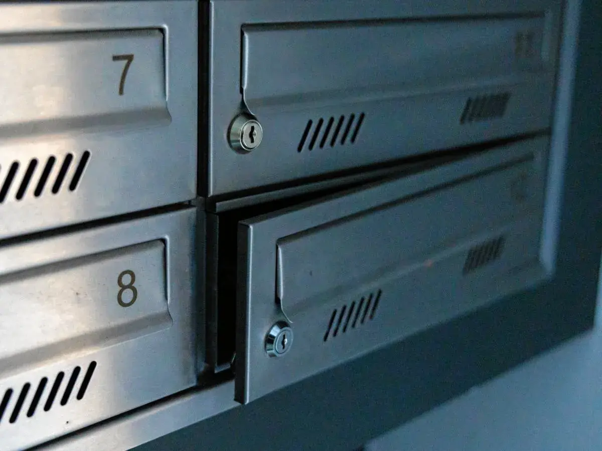 Metalowe skrytki pocztowe z numerami 7 i 8. Jedna z nich jest uchylona, ukazując zamek.