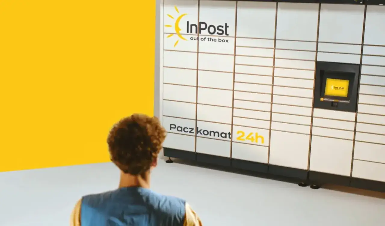 Mężczyzna odbiera paczkę z Paczkomatu InPost. To jedna z wielu zalet zakupów online: wygoda i dostępność 24/7.