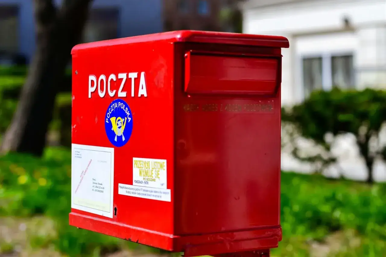 Czerwona skrzynka pocztowa Poczty Polskiej. Na niej napis 
