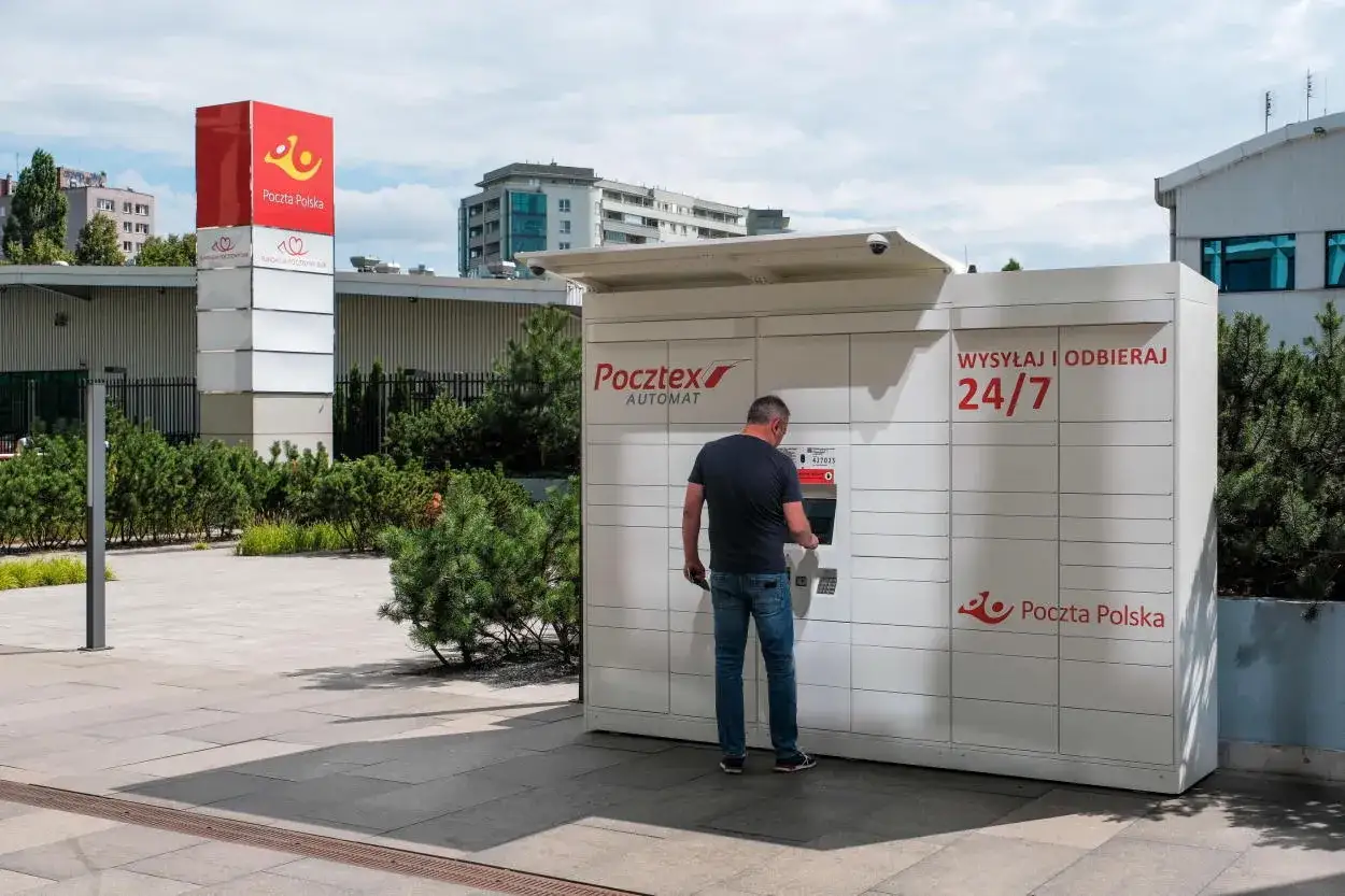Mężczyzna korzysta z automatu Pocztex, bo wie, że poczta nie ma go w domu.